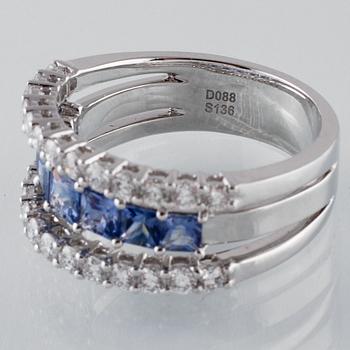 RING, 18K vitguld med 26 briljantslipade diamanter 0.88 ct samt 7 blå safirer 1.36 ct. Vikt 7,8 gram.