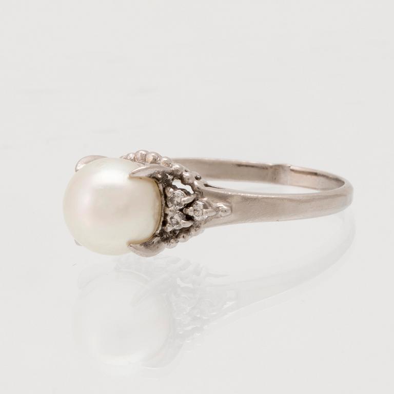 Ring in 900 platinum with a cultured pearl and round brilliant-cut diamonds.