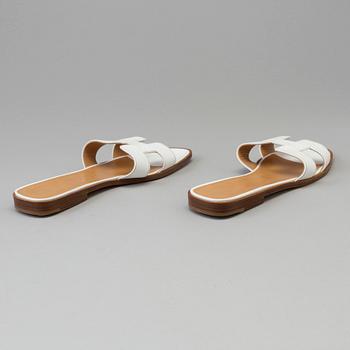 A pair of white leather shoes by Hermès.
