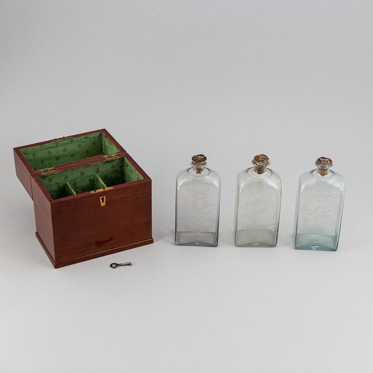 A late Empire mahogany box with three glass bottles, mid 19th Century.