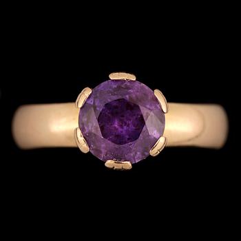 RING, 18k guld med rund fasettslipad violett sten. Vikt 5,7g.