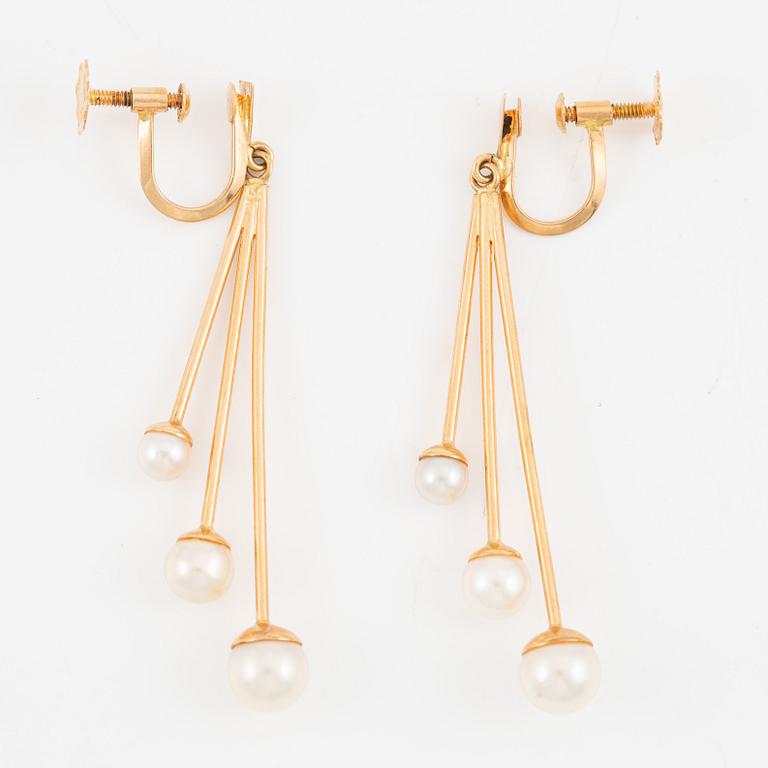 A pair of earrings in 18K gold with cultured pearls.