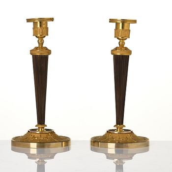 A pair of Empire ormolu and patinated bronze candlesticks.