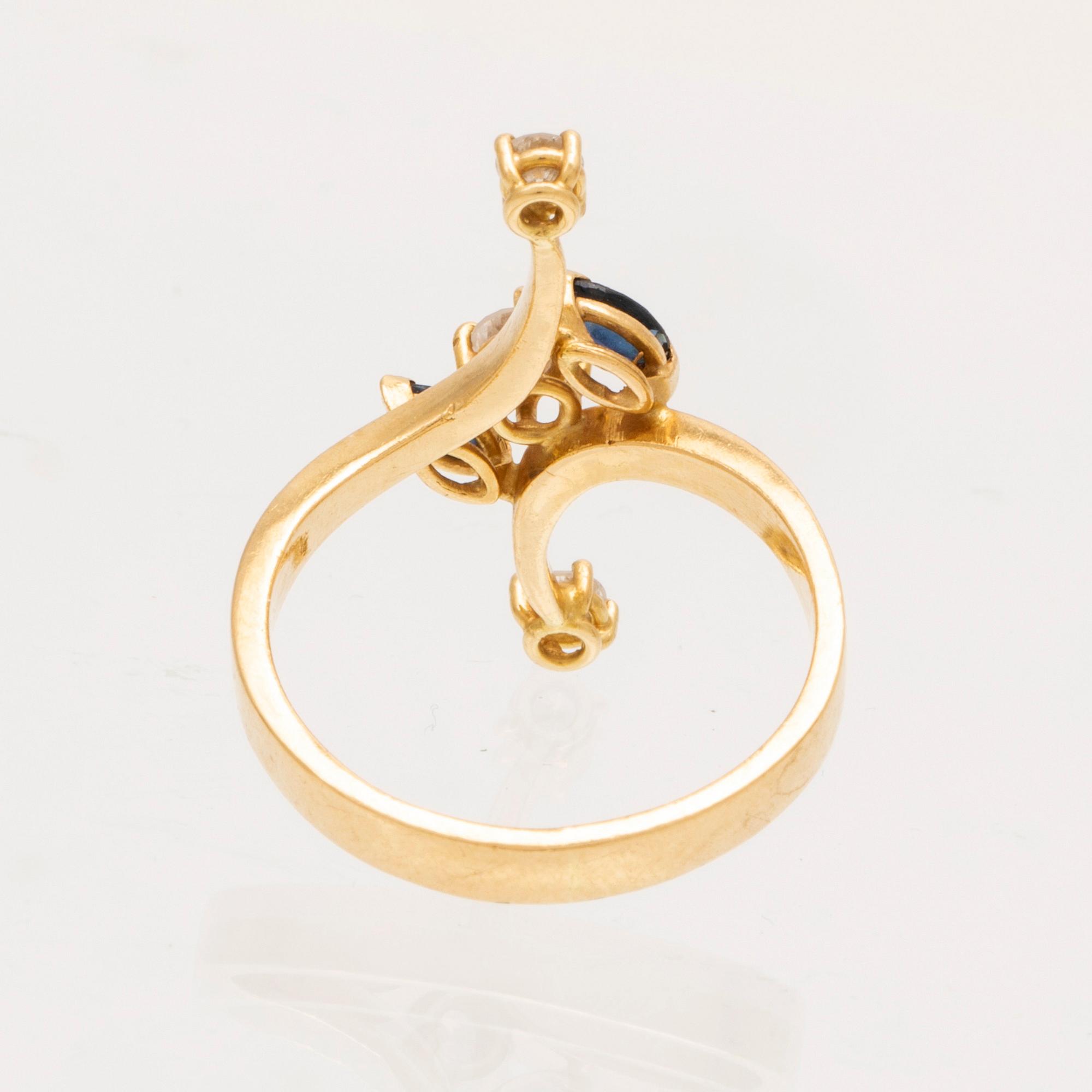 An 18K gold ring with marquise cut sapphires and round brilliant cut diamonds.