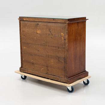A mahogany veneered Empire chest of drawers, first half of the 20th Century.