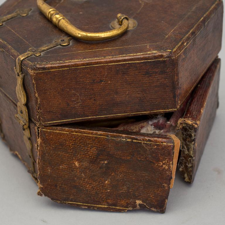A gilded brass baroque travel clock from around 1700, with original case.
