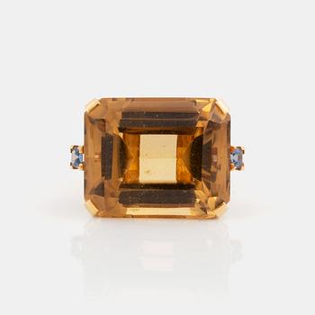 543. An 18K gold ring set with a faceted citrine and two sapphires.