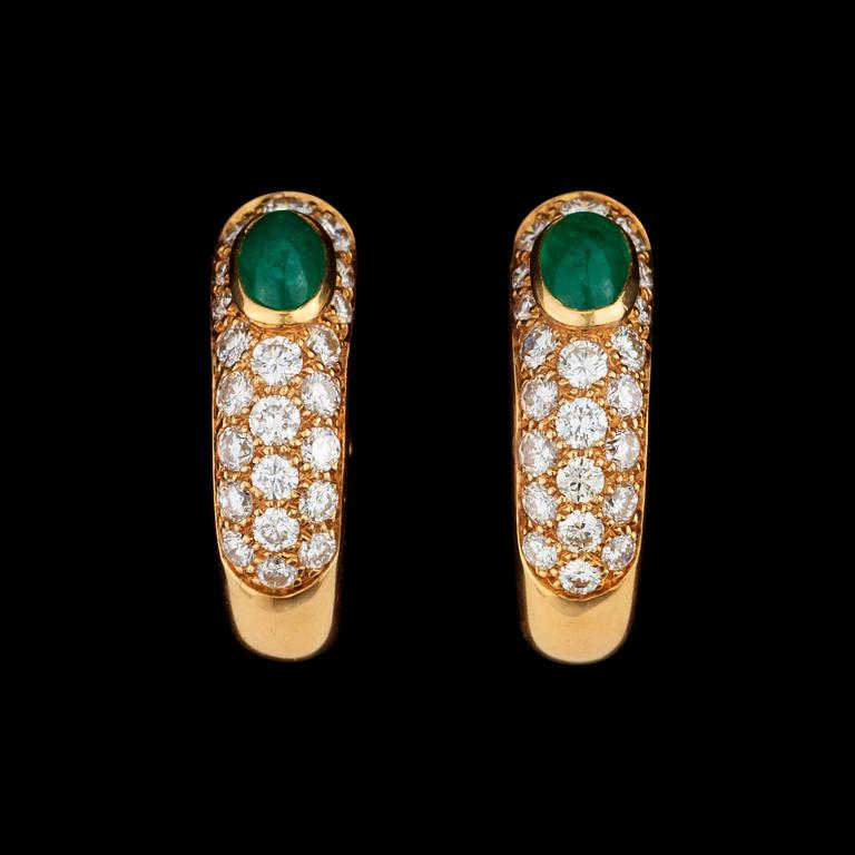 A pair of Cartier earrings set with emeralds and brilliant cut diamonds.