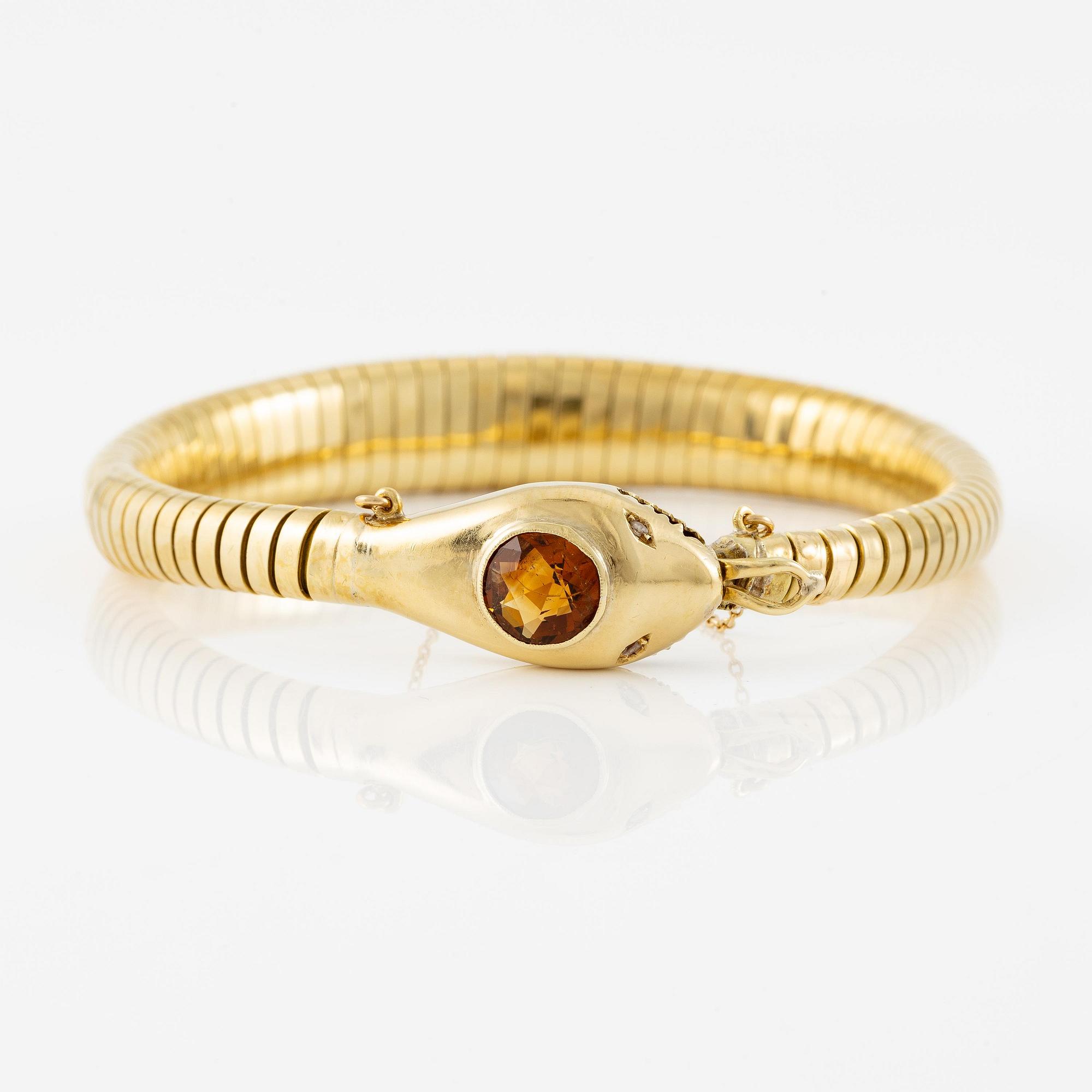 A bracelet in the shape of a serpent in 18K gold with a faceted citrine and rose-cut diamonds.