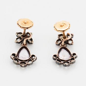 Ett par örhängen silver och guld med fasettslipad droppformad rosa topas.