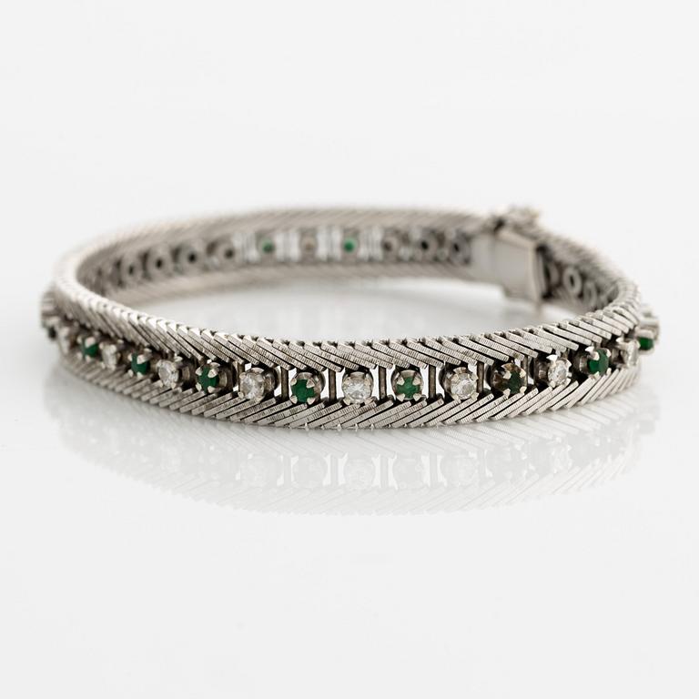 Bracelet 18K gold with round brilliant-cut diamonds and green stones, likely emeralds.