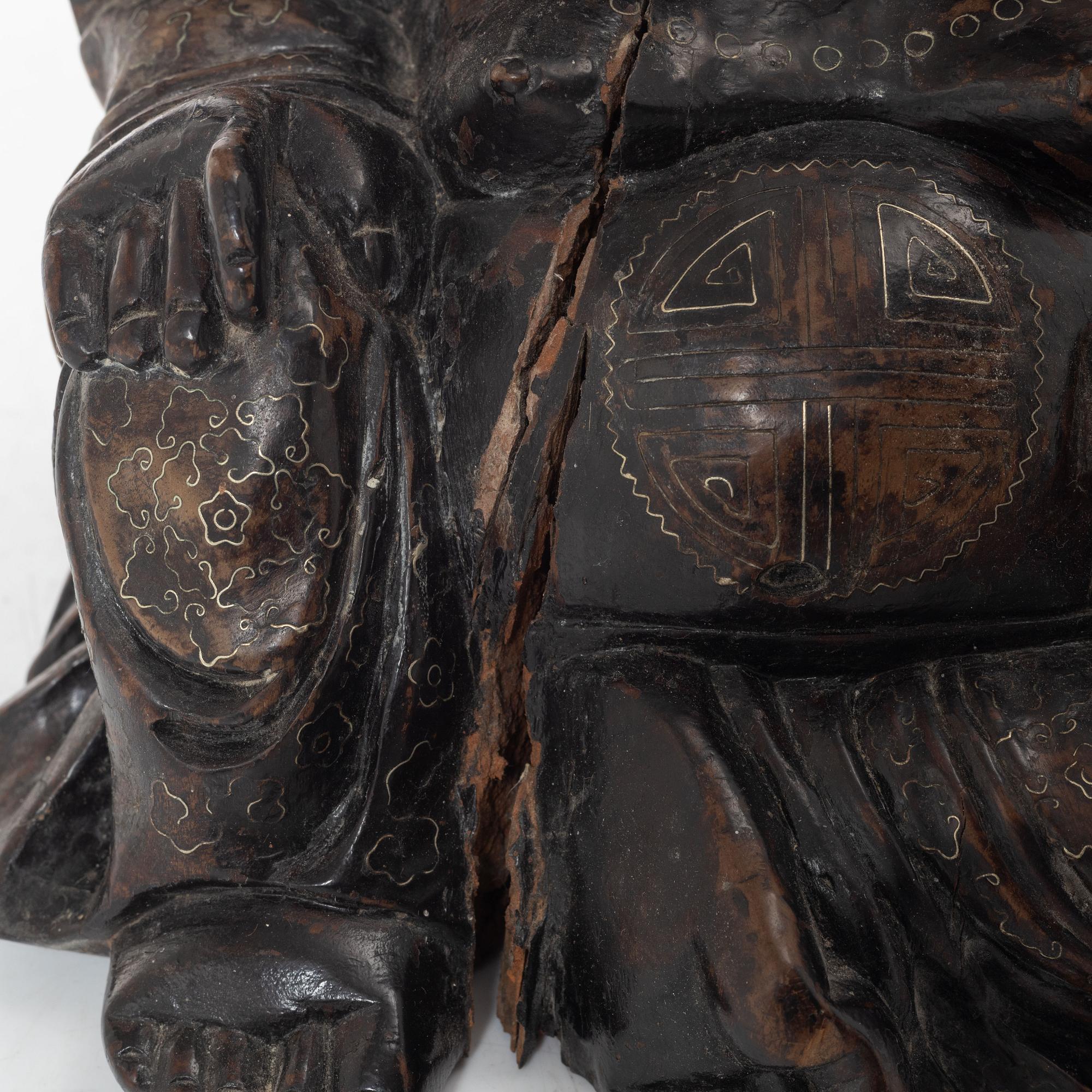 A Chinese wooden figure of Budai with silver inlays, Qing dynasty (1644-1912).