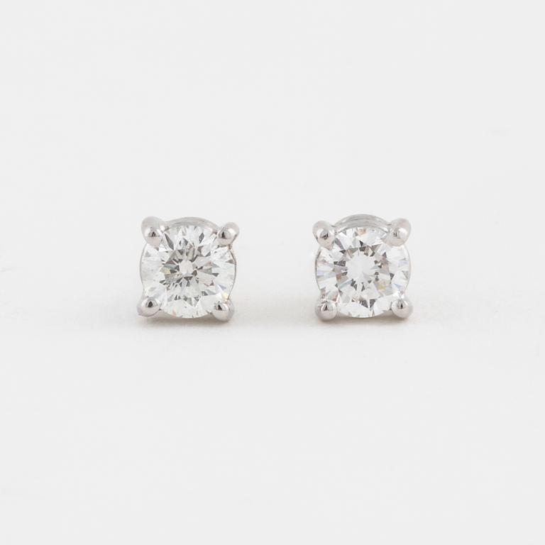 A pair of brilliant cut diamond earrings.