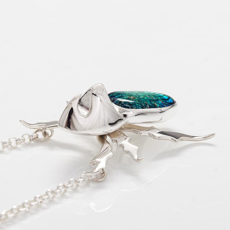 A stelring silver necklace "Rhinoceros beetle" with dichroic glass. Ru Runeberg 2019.