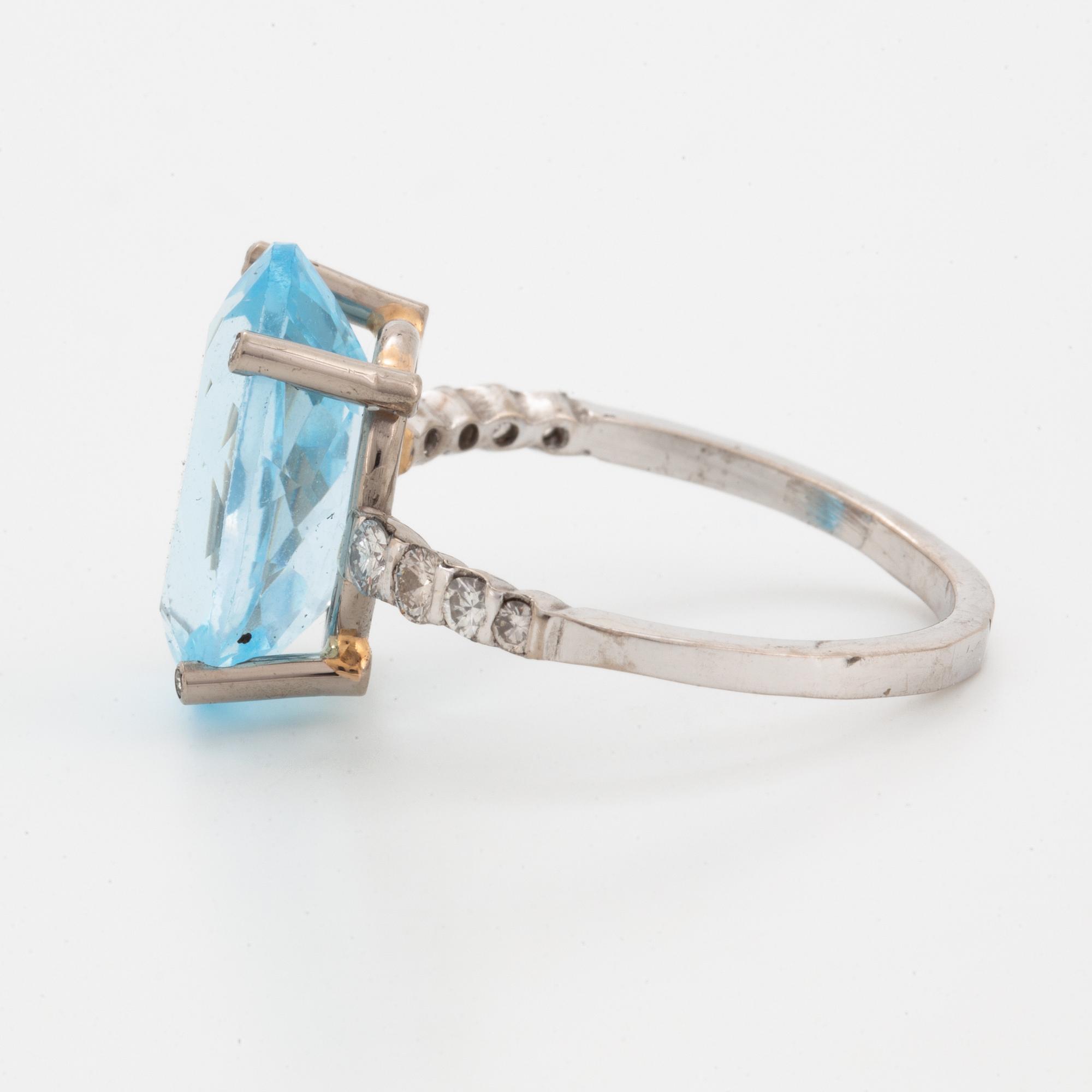 Oval faceted blue topaz and brilliant-cut diamond cocktail ring.