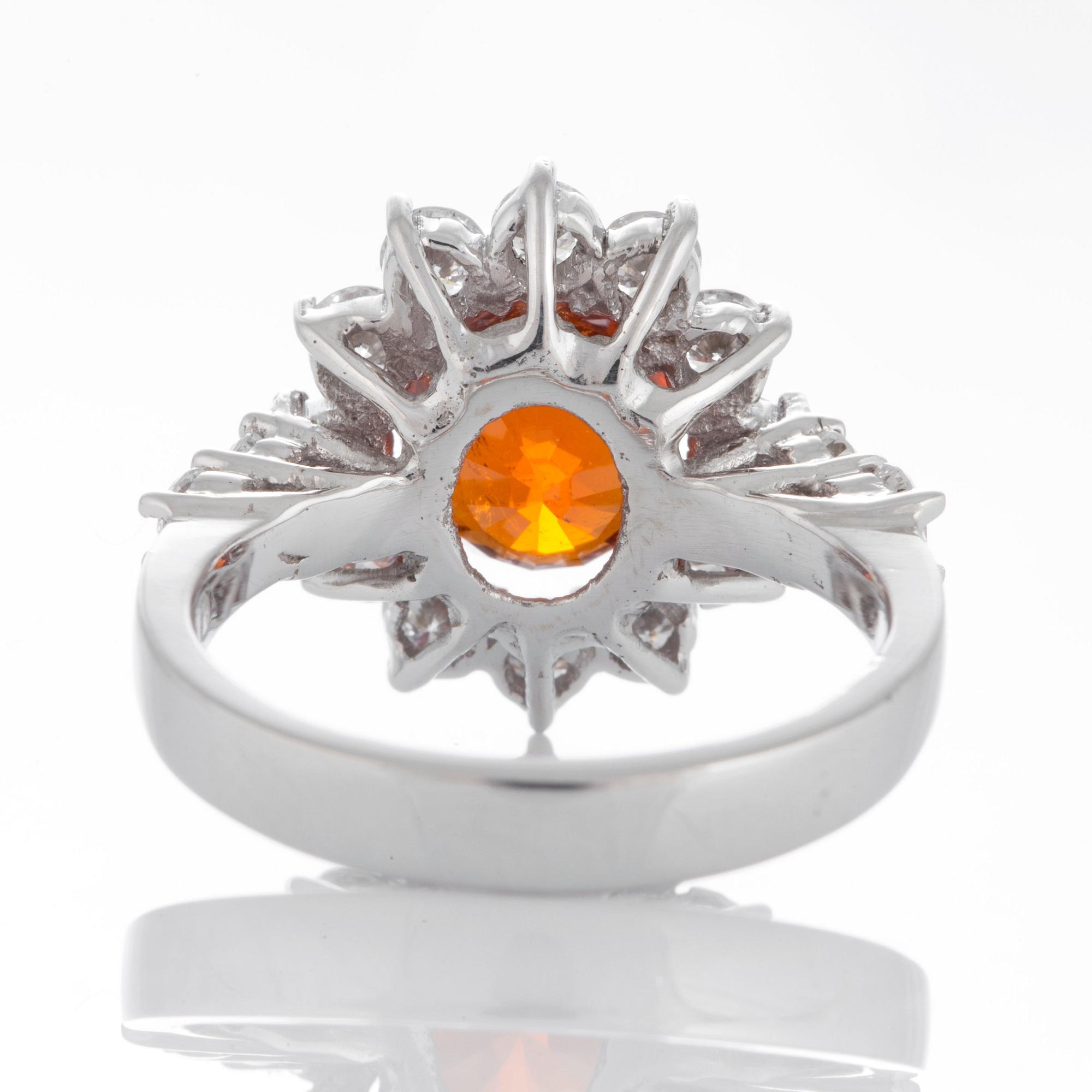 Ring med en fasettslipad spessartingranat samt runda briljantslipade diamanter.