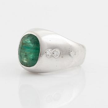 An 18K white old ring set with a faceted emerald and round brilliant-cut diamonds.