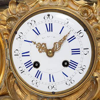 A Rococo style mantle clock and pair of candelabra, France, late 19th Century.