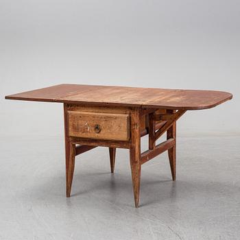 A 19th Century table with drop leaves.