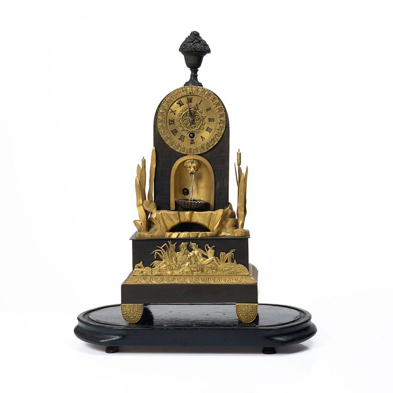 A French Charles X ormolu and patinated bronze mantel clock, ca 1820's.