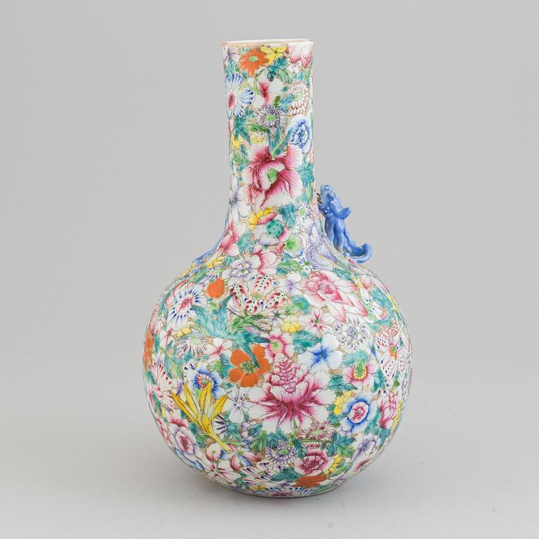 A chinese globular shaped vase, richly decorated with flowers and a dragon and a bat, second half of the 20th century.