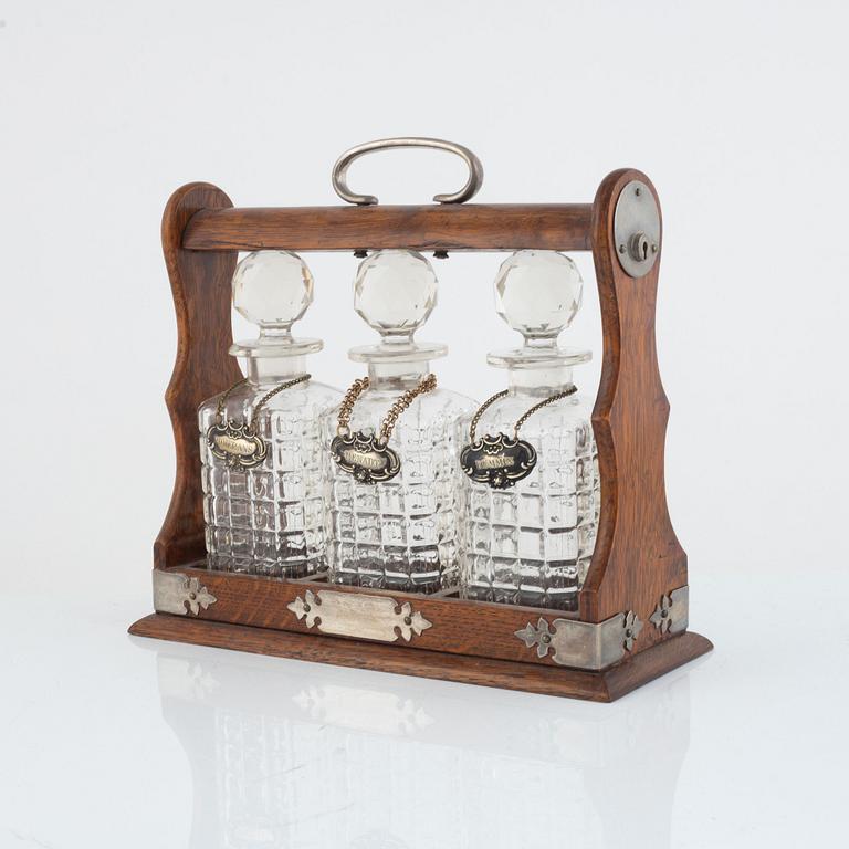 A mahogany and electroplate tantalus witht three carafes, circa 1900.