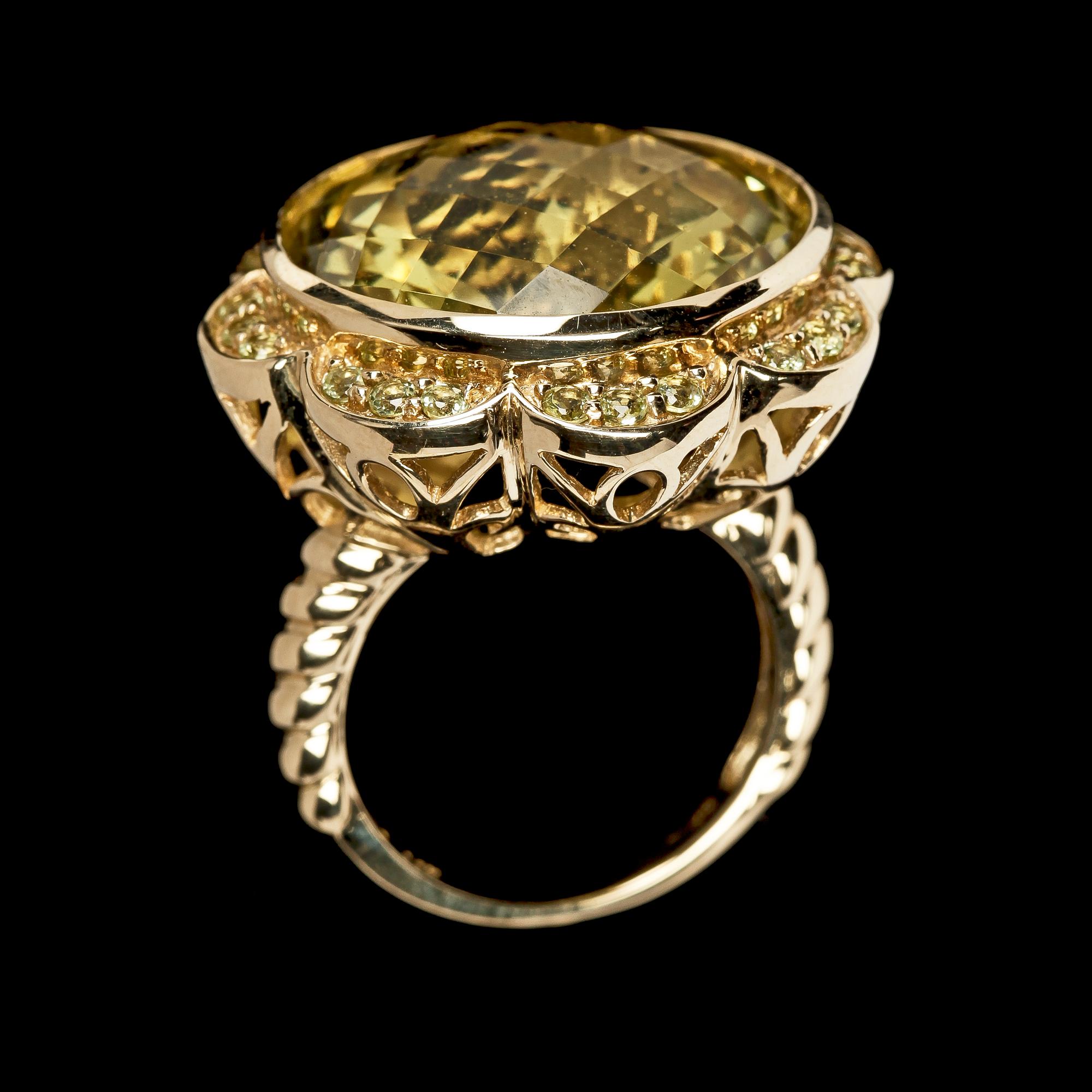RING, fasettslipad stor citrin med små gröna peridoter runt om.