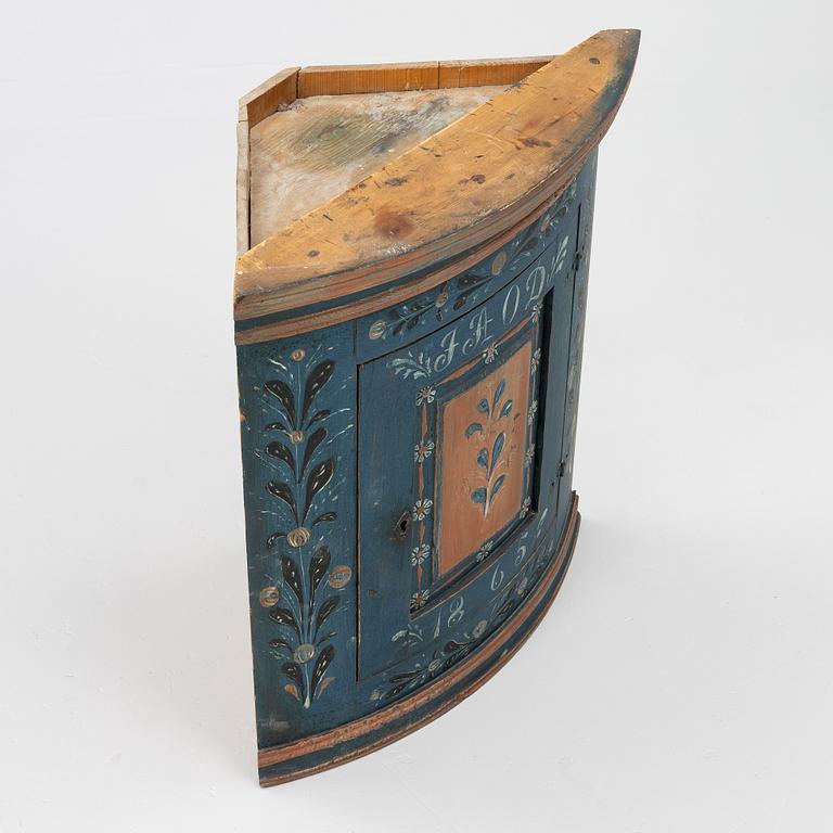 A folk art corner cabinet from Delsbo, Hälsingland, dated 1865.