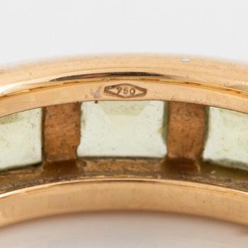 An 18K gold ring set with step-cut peridots.