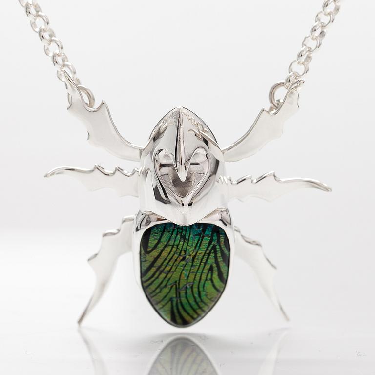 A stelring silver necklace "Rhinoceros beetle" with dichroic glass. Ru Runeberg 2019.