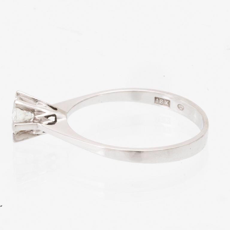 An 18K white gold solitaire ring set with a round brilliant-cut diamond.