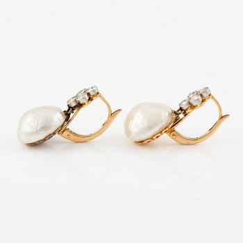 A pair of earrings in 18K gold with button-shaped saltwater pearls and old-cut diamonds.