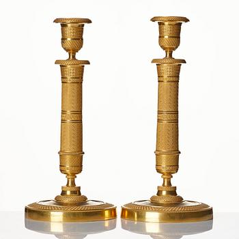 A pair of French gilded Empire candlesticks.