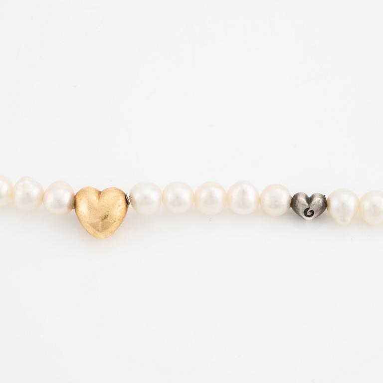 Ole Lynggaard 18K gold clasp in the shape of a heart with a cultured freshwater pearl necklace with a silver heart.