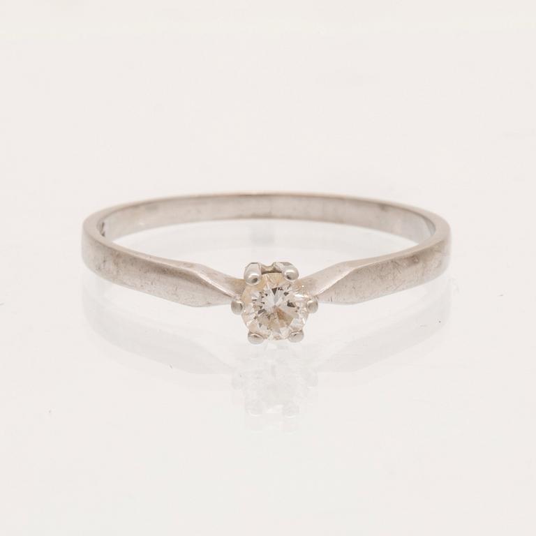 An 18K white gold ring with a round brilliant cut diamond.