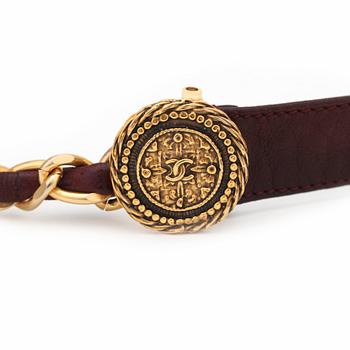 CHANEL, a burgundy red leather belt with gold colored metal chain.