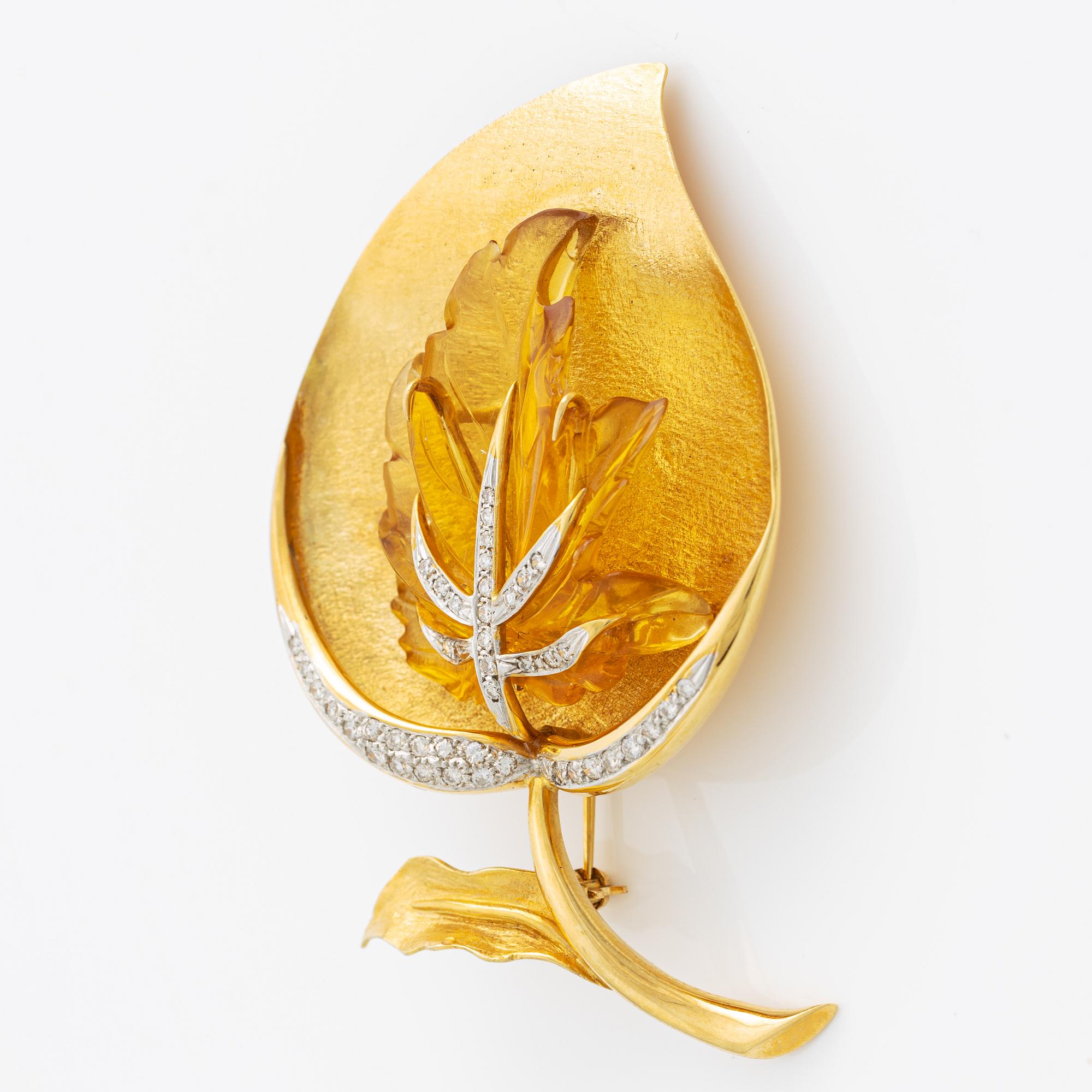 Brooch in 18K gold with carved stone, likely citrine, with round brilliant-cut diamonds.
