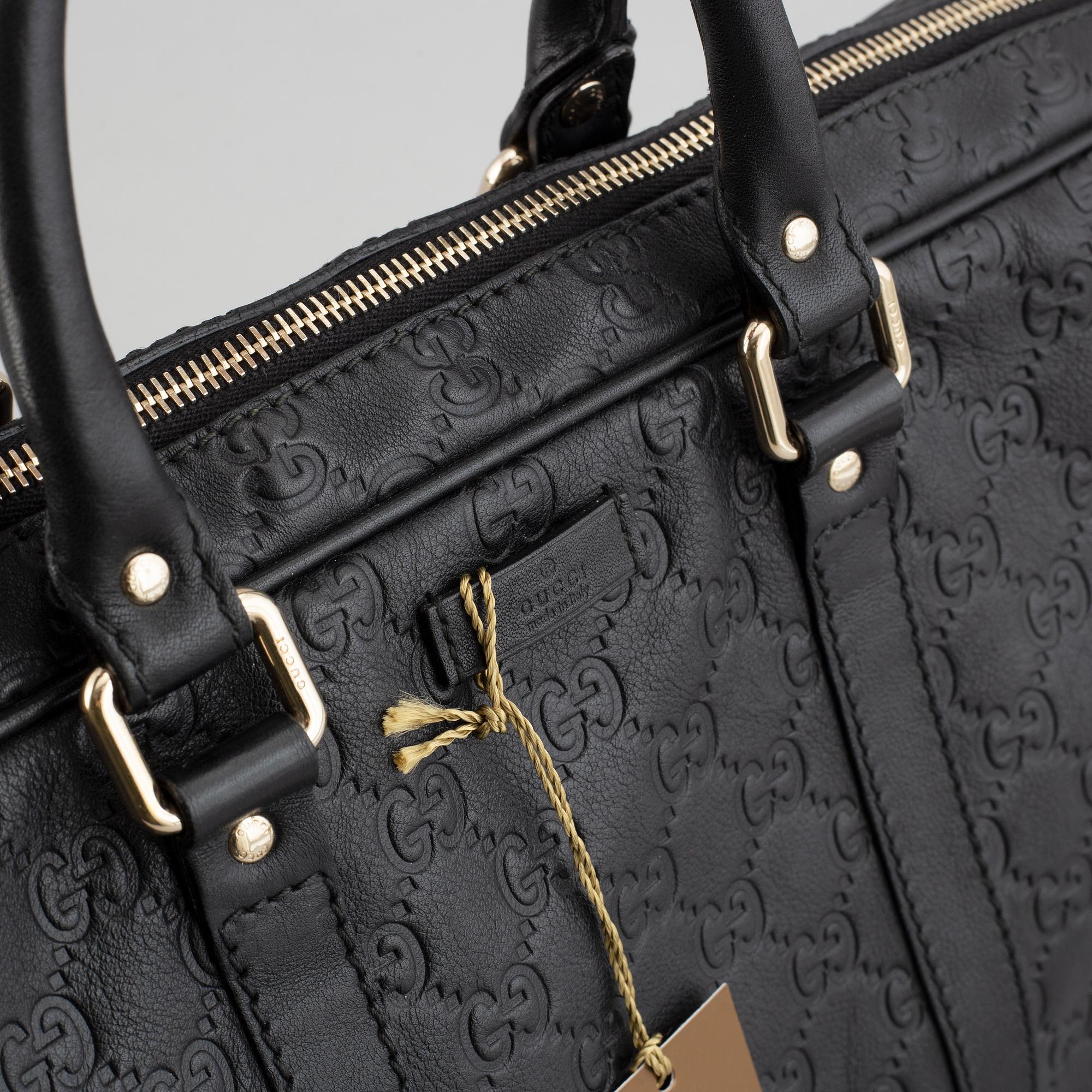 Gucci, a monogram leather bag/laptop-bag.
