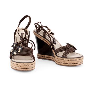 583. LOUIS VUITTON, a pair of straw and brown leather wedge sandals.