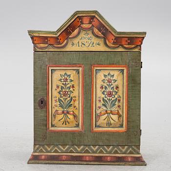A hanging cabinet, dated 1832.