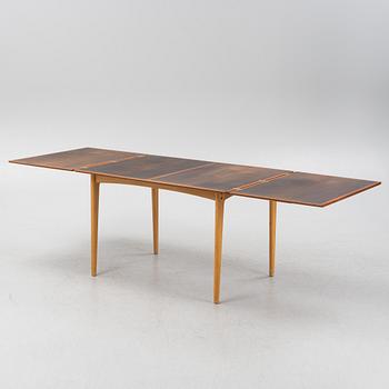 A 1960's teak and rosewood veneered dining table.