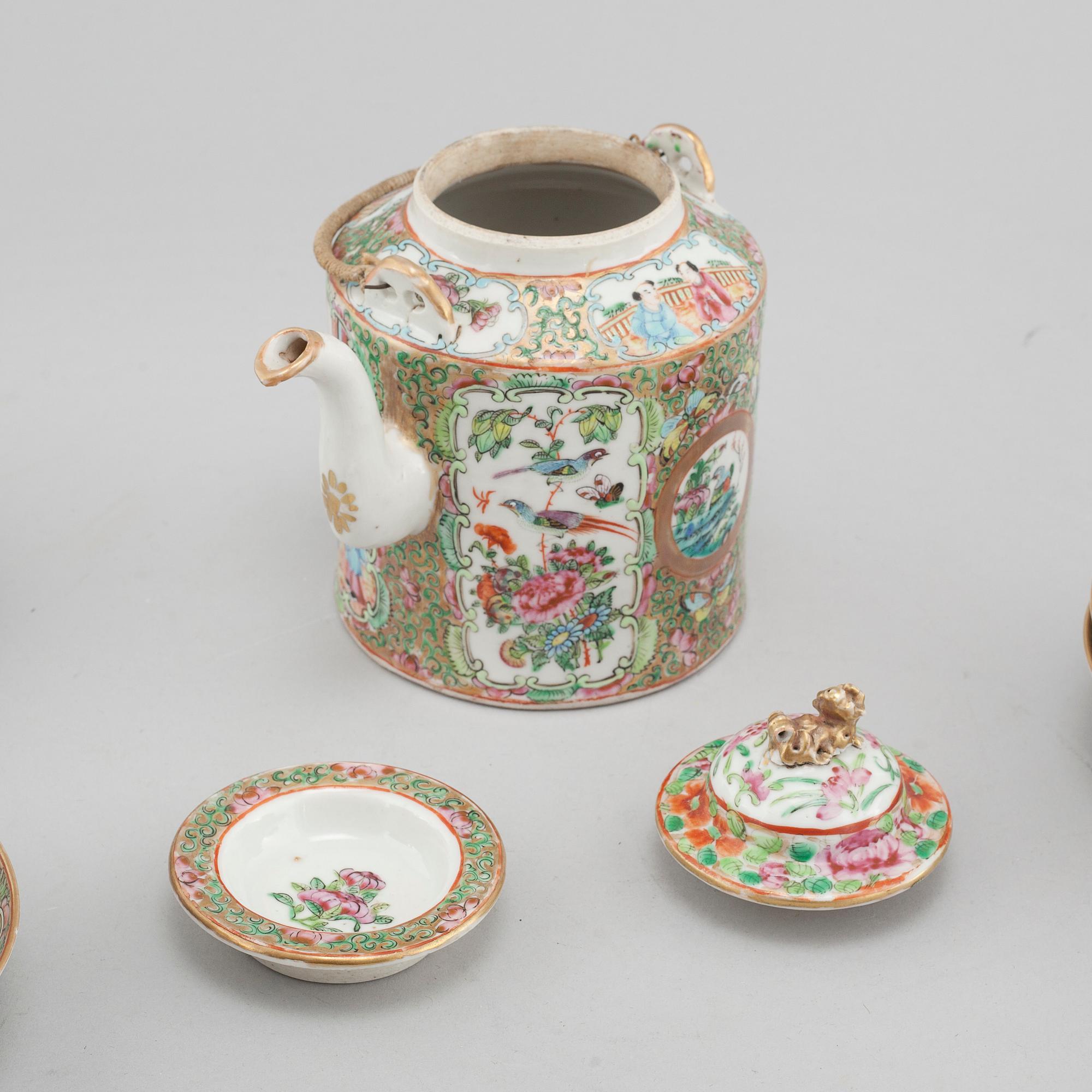 A chinese porcelain tea pot and four plus one cup, around the year 1900.