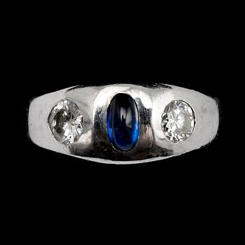 RING, 18 k vitguld, GK Stockholm 1967 med briljanter tot 0,65 ct och cabochonslipad oval blå safir.