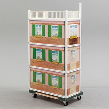 A plastic doll's house with six dolls, furniture and clothes, 20th century.