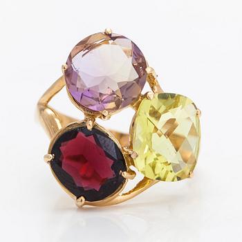 An 18K gold ring, with a garnet, citrine, and an amethyst.