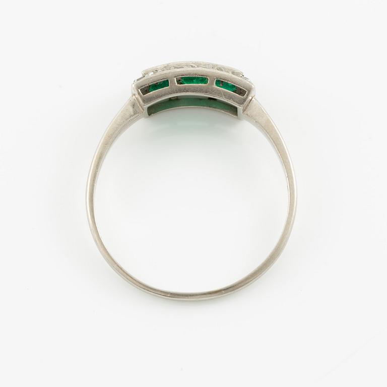 Ring in platinum set with step-cut emeralds and rose-cut diamonds.