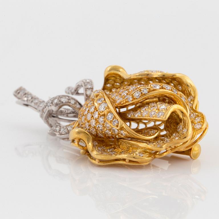 An 18K gold and platinum brooch in the shape of a rose set with eight-cut diamonds.