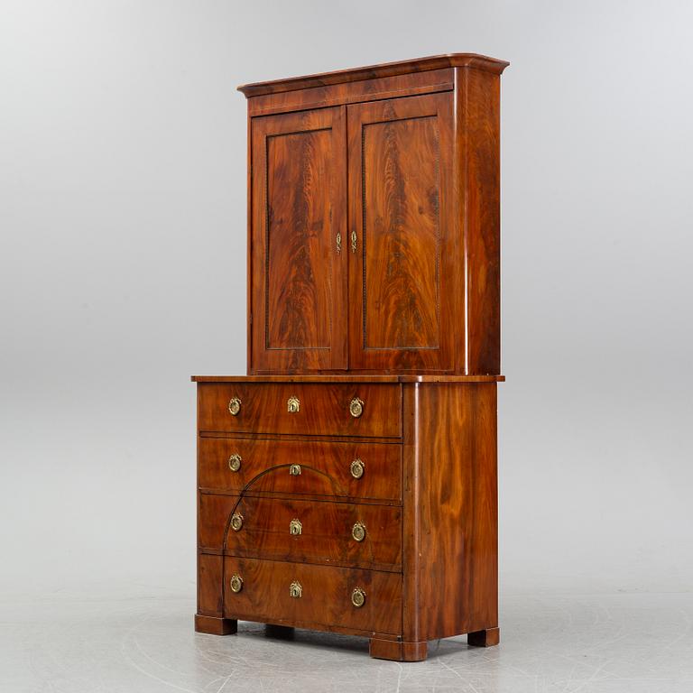 A mahogany veneered Empire cupboard, first half of the 19th century.