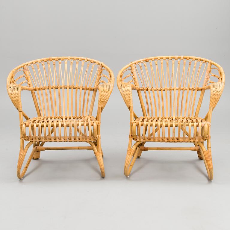 A pair of rattan arm chairs from the latter half of the 20th Century.