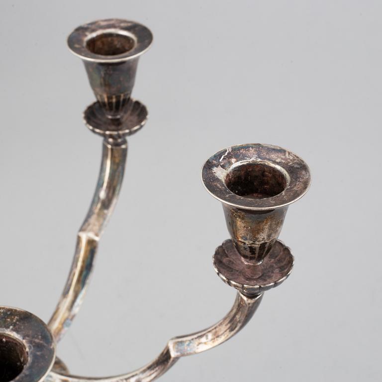 A pair of Swedish Grace silver candelbar for        five candles, mark of GAB, Stockholm, 1929.